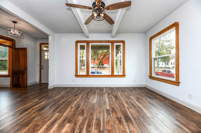 spare room featuring dark wood-type flooring, a wealth of natural light, and beam ceiling