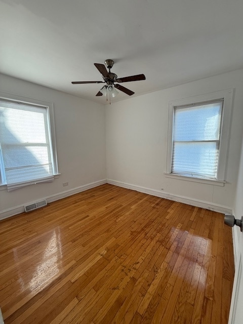 empty room featuring hardwood / wood-style flooring and ceiling fan