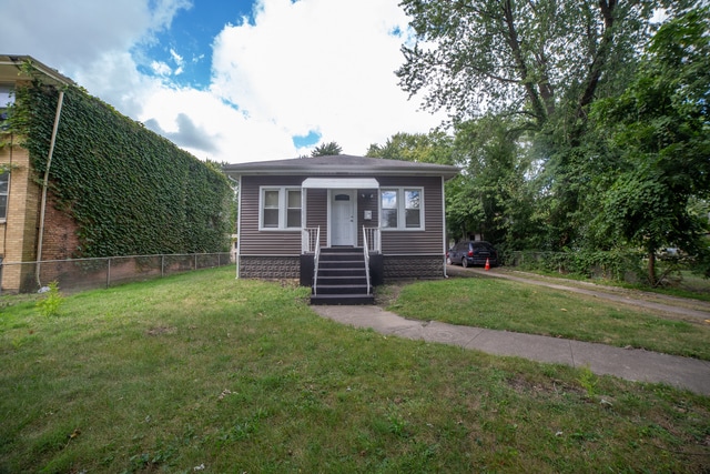 bungalow-style house featuring a front lawn