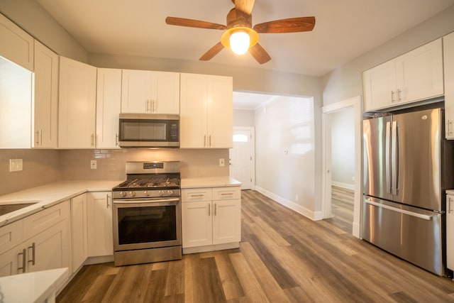 kitchen with white cabinetry, decorative backsplash, stainless steel appliances, and dark wood-type flooring