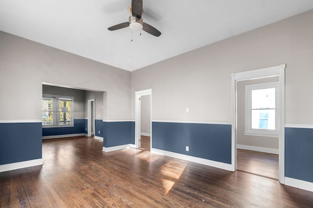 unfurnished room featuring plenty of natural light, ceiling fan, and dark hardwood / wood-style flooring