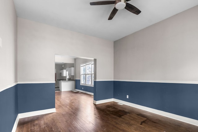 empty room featuring ceiling fan and dark hardwood / wood-style flooring