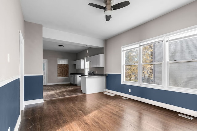 unfurnished living room with ceiling fan and dark hardwood / wood-style floors