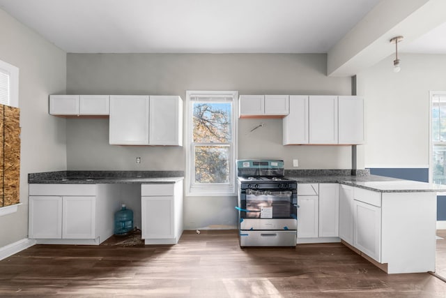 kitchen with white cabinets, dark hardwood / wood-style flooring, decorative light fixtures, and stainless steel gas range oven