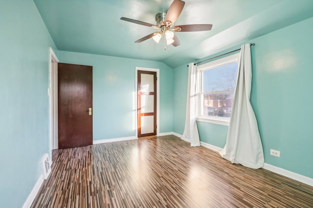 empty room with ceiling fan, dark wood-type flooring, and vaulted ceiling