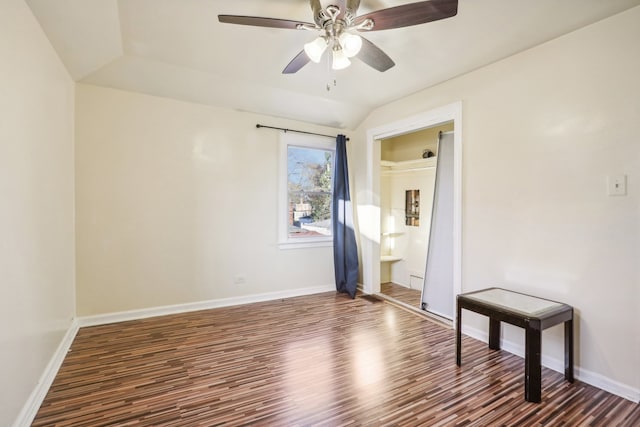 empty room with ceiling fan, lofted ceiling, and dark wood-type flooring