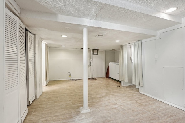 basement featuring washer / dryer and a textured ceiling