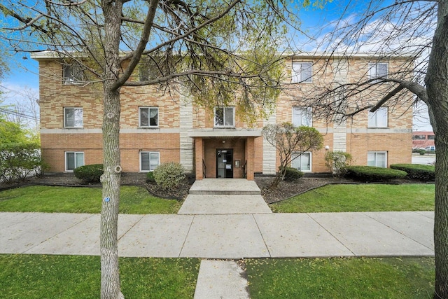 view of front of property featuring brick siding and a front lawn