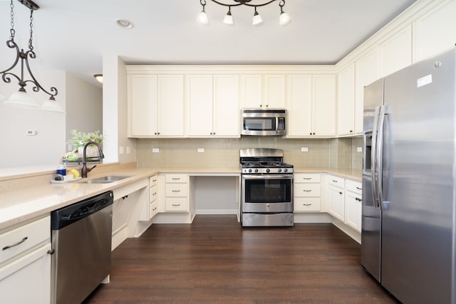 kitchen with sink, decorative backsplash, appliances with stainless steel finishes, hanging light fixtures, and dark hardwood / wood-style flooring