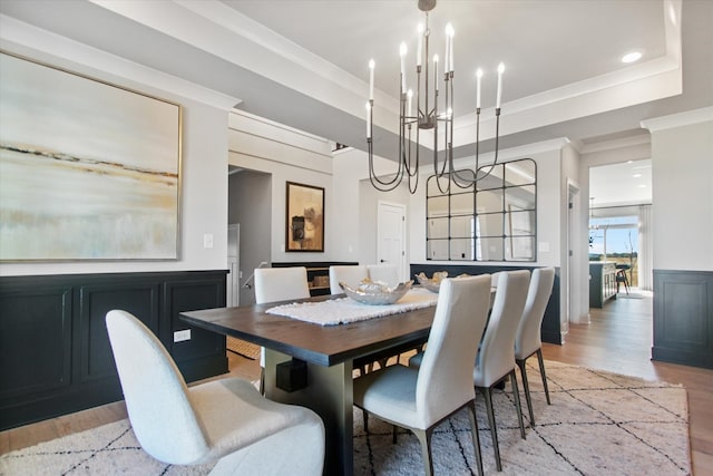 dining area with a raised ceiling and light wood-type flooring