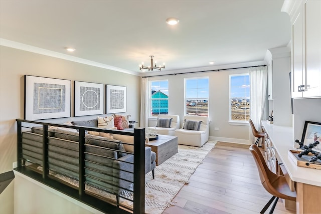 living room featuring light hardwood / wood-style floors, crown molding, and a notable chandelier