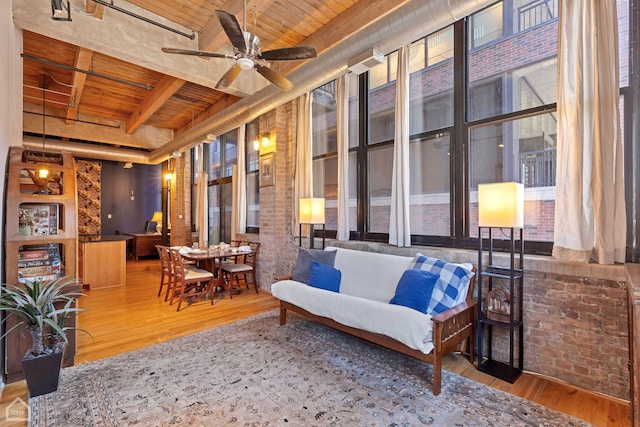 interior space featuring a healthy amount of sunlight, wood ceiling, hardwood / wood-style flooring, ceiling fan, and beam ceiling