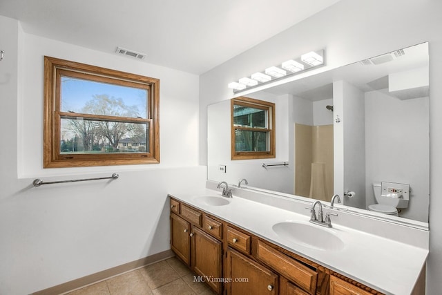 bathroom with tile patterned flooring, vanity, and toilet