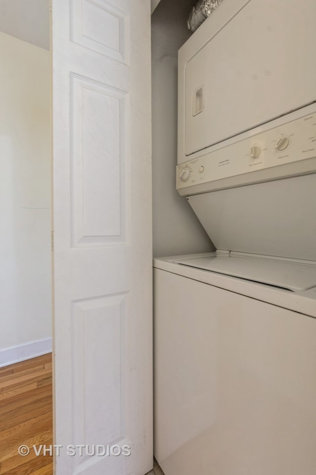 washroom featuring stacked washer / drying machine and light hardwood / wood-style flooring