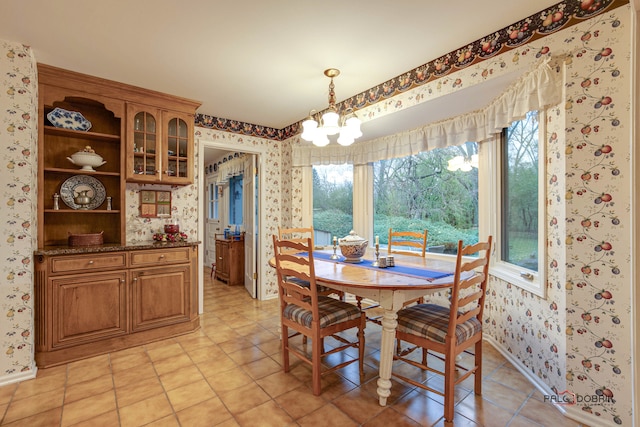 dining area with light tile patterned floors and a notable chandelier