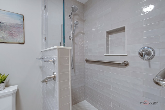 bathroom featuring toilet and tiled shower