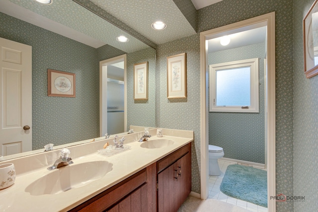 bathroom with tile patterned floors, vanity, toilet, and a shower with shower door