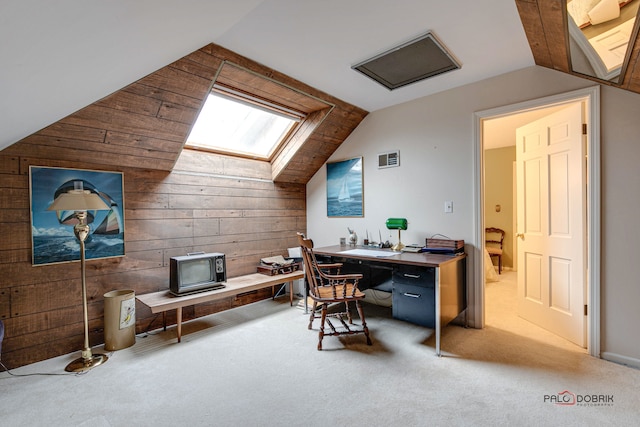 carpeted office with wood walls and vaulted ceiling with skylight