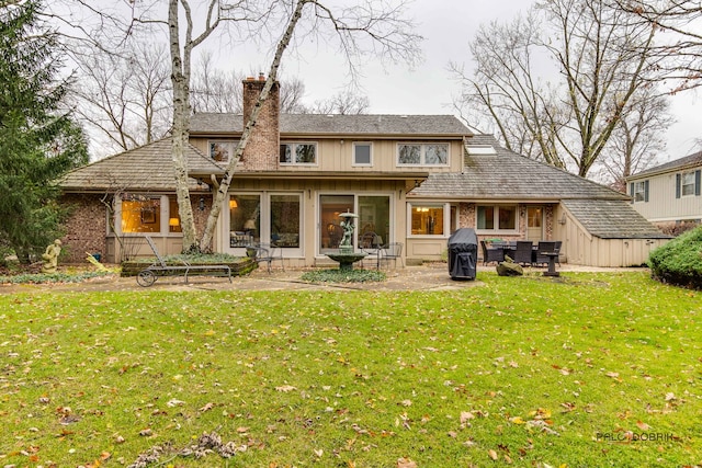 rear view of house with a lawn and a patio area