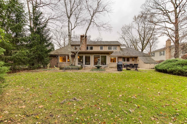 back of house featuring a lawn and a sunroom