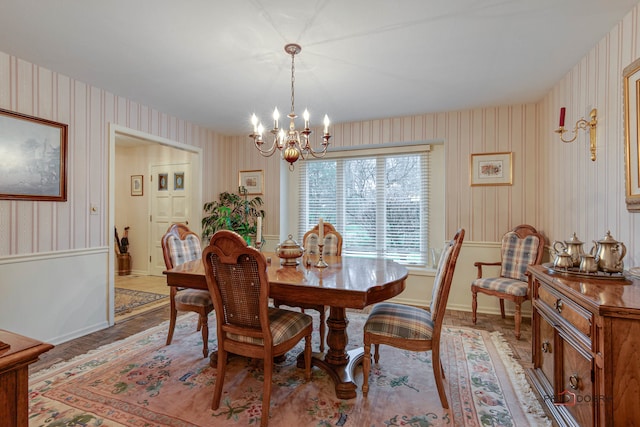 dining area with light hardwood / wood-style floors and an inviting chandelier