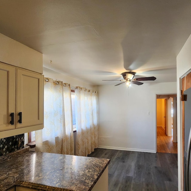 kitchen with cream cabinets, dark hardwood / wood-style floors, dark stone countertops, and ceiling fan