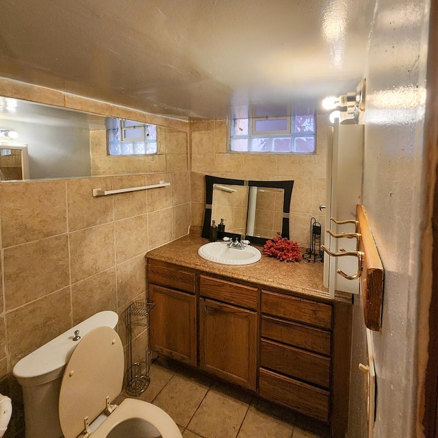 bathroom with vanity, toilet, tile patterned flooring, and tile walls