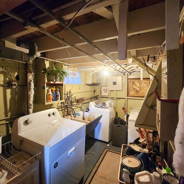 clothes washing area featuring electric panel, separate washer and dryer, and sink