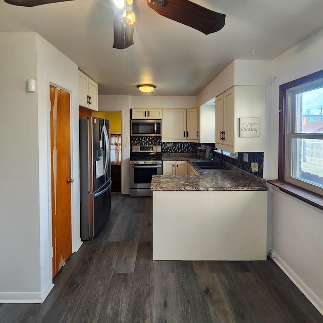 kitchen featuring sink, stainless steel appliances, dark hardwood / wood-style flooring, decorative backsplash, and kitchen peninsula