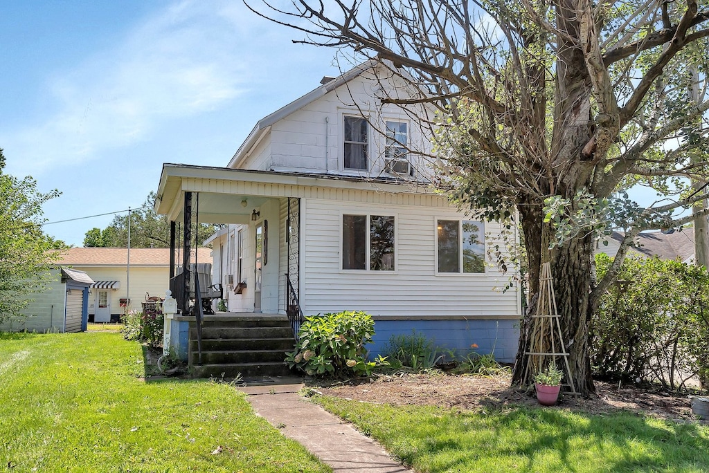 view of front of home with a front yard and covered porch