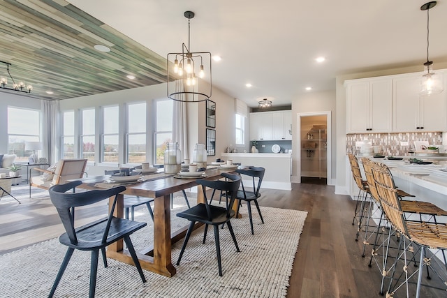 dining area featuring dark wood-type flooring and a notable chandelier