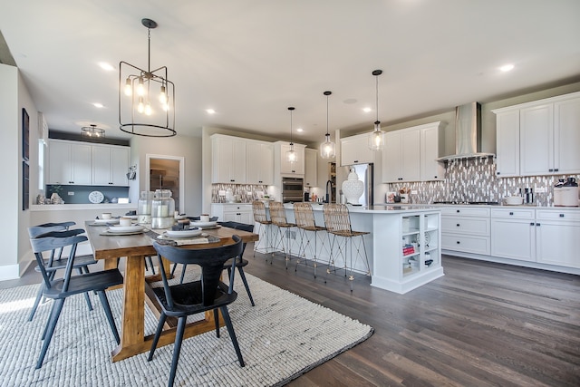 dining space featuring sink, an inviting chandelier, and dark hardwood / wood-style flooring