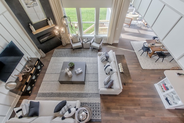 living room featuring dark wood-type flooring, a chandelier, and a high ceiling