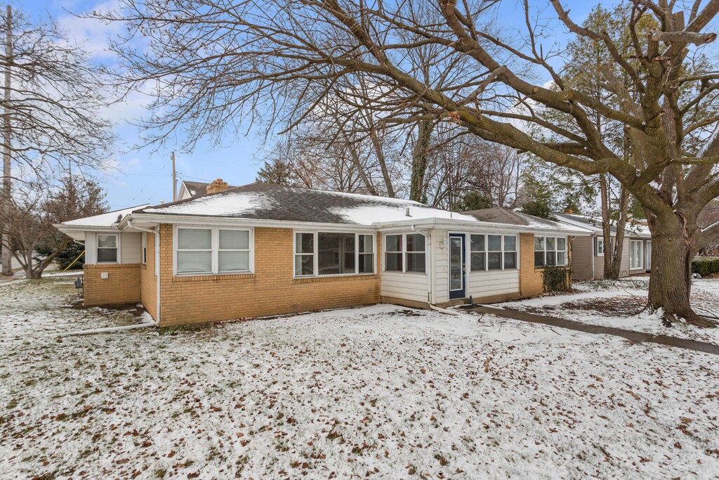 snow covered property with a sunroom