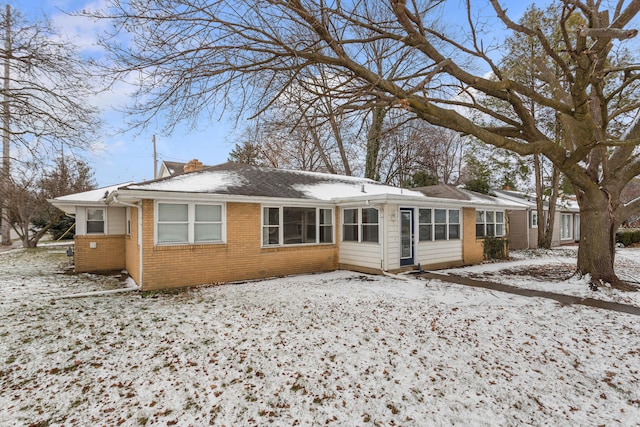 snow covered property with a sunroom