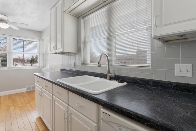 kitchen featuring tasteful backsplash, white cabinetry, sink, and ceiling fan