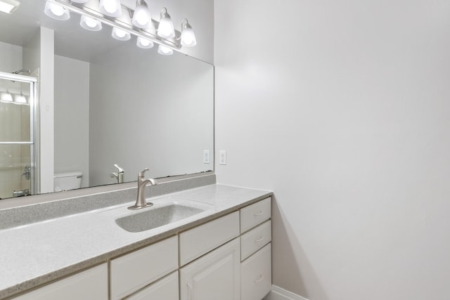 bathroom featuring an enclosed shower, vanity, and toilet