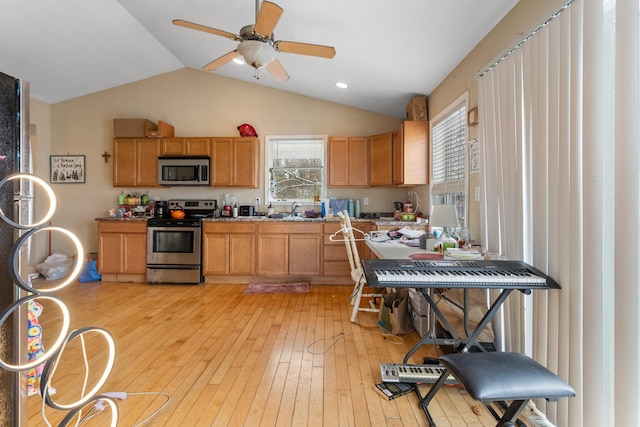 kitchen with ceiling fan, plenty of natural light, stainless steel appliances, and light wood-type flooring