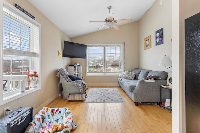 living room featuring ceiling fan, plenty of natural light, lofted ceiling, and light wood-type flooring