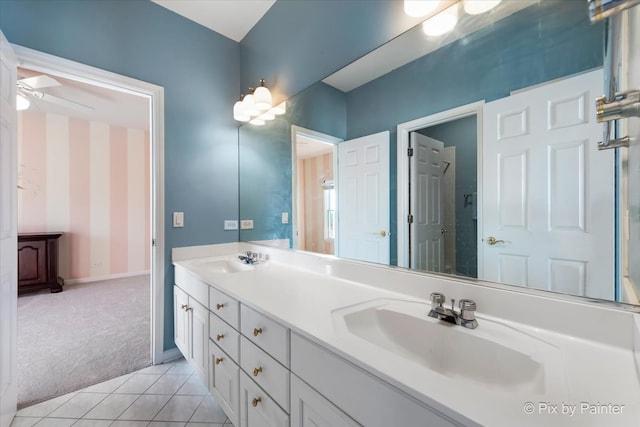 full bathroom with double vanity, a sink, baseboards, and tile patterned floors