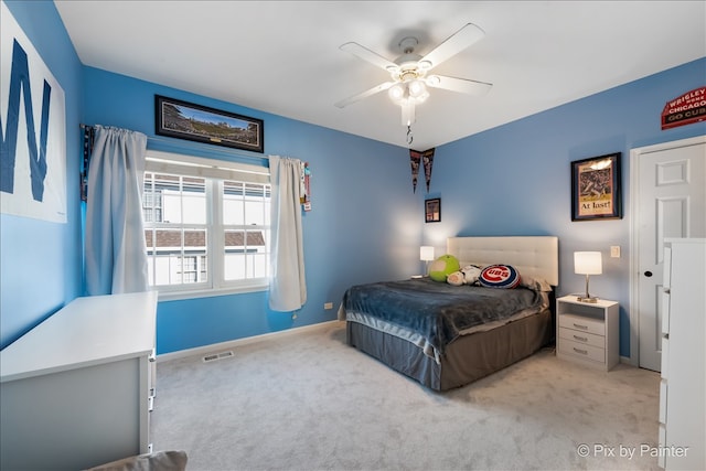 carpeted bedroom with a ceiling fan, visible vents, and baseboards