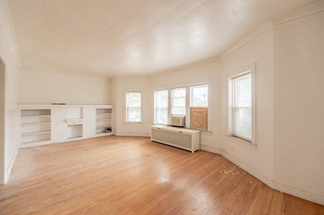 unfurnished living room featuring hardwood / wood-style flooring, radiator heating unit, and ornamental molding