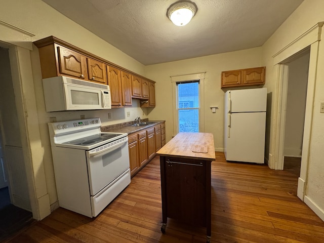 kitchen with wood counters, white appliances, dark hardwood / wood-style floors, a textured ceiling, and a kitchen island