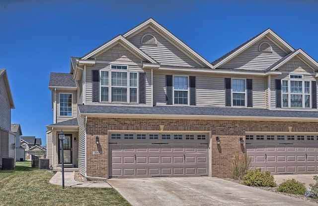 view of property featuring an attached garage, a shingled roof, concrete driveway, and brick siding