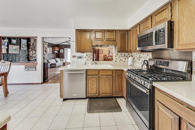 kitchen featuring light tile patterned floors, backsplash, stainless steel appliances, and sink