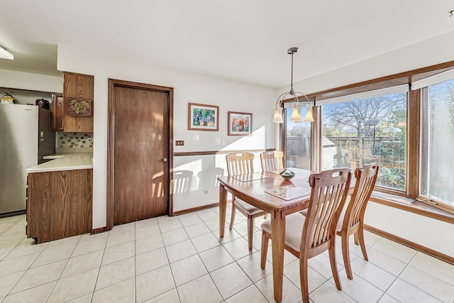 dining area with light tile patterned floors and a notable chandelier