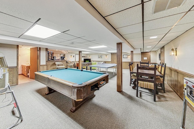 rec room featuring a paneled ceiling, light carpet, wood walls, and pool table