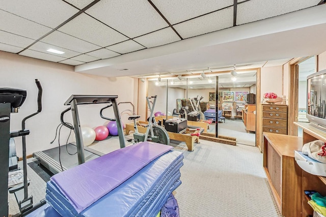 workout area featuring a paneled ceiling, rail lighting, and light colored carpet