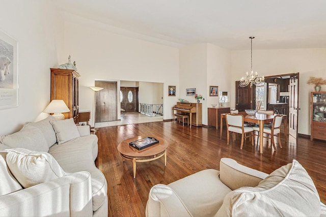 living room with dark hardwood / wood-style floors, high vaulted ceiling, and a notable chandelier