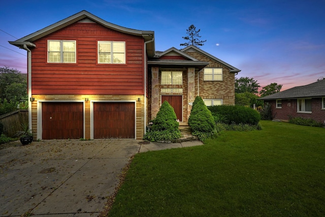 front facade featuring a garage and a lawn